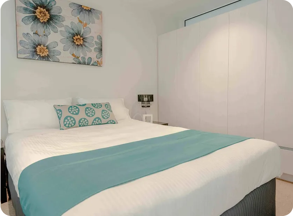 Modern bedroom with floral artwork and decor.