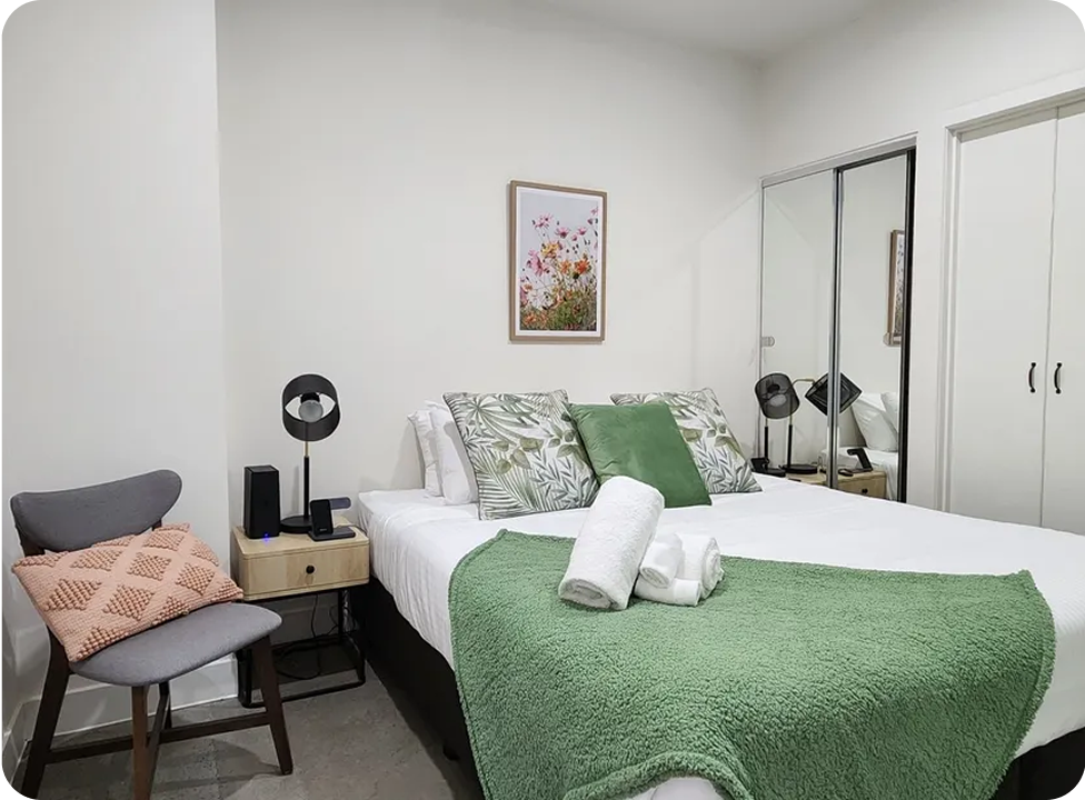 Cozy bedroom with green accents and decor.