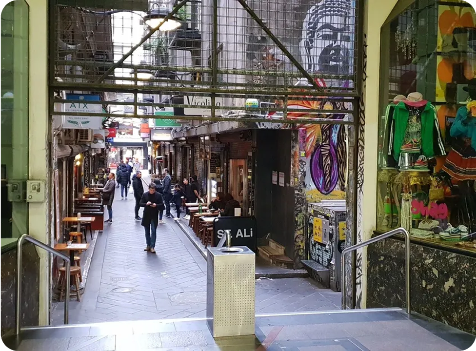 Narrow alleyway with cafes and graffiti art.
