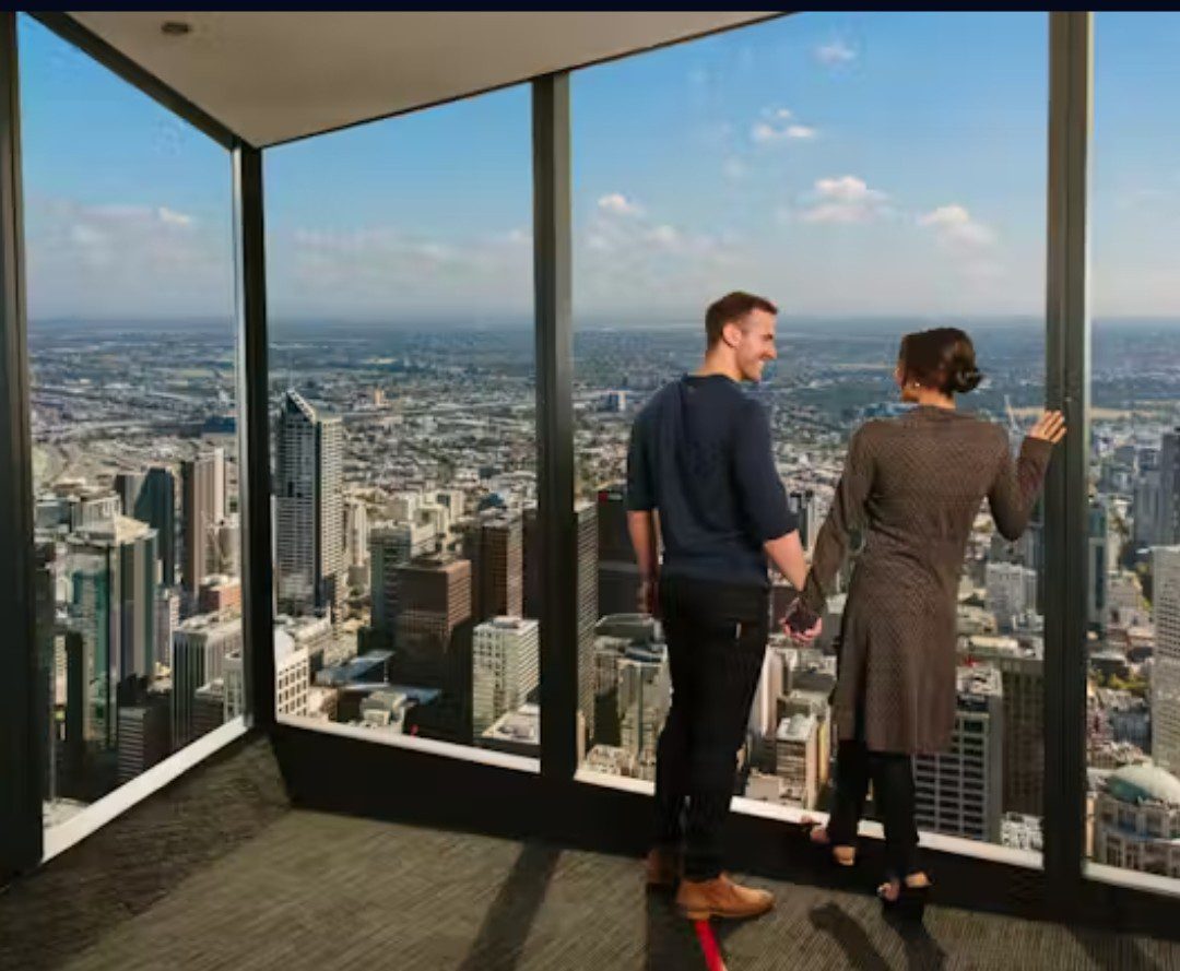 Two men in a high-rise office overlooking the cityscape.