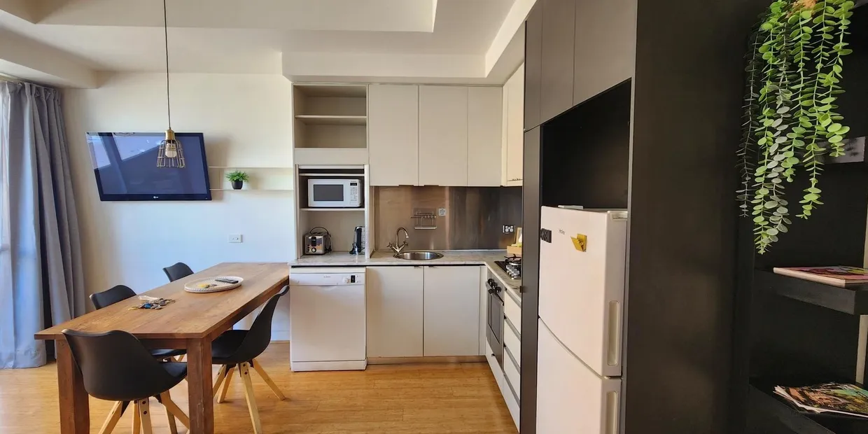 Modern kitchen and dining area with plants.