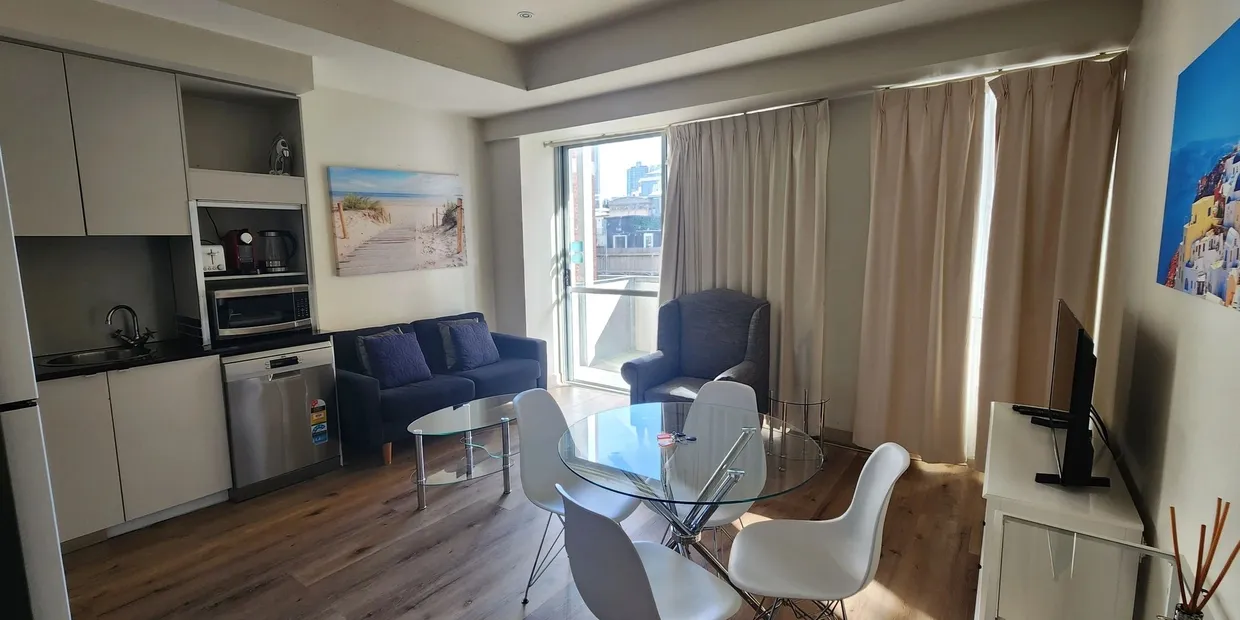 Modern living room with kitchen and dining area.